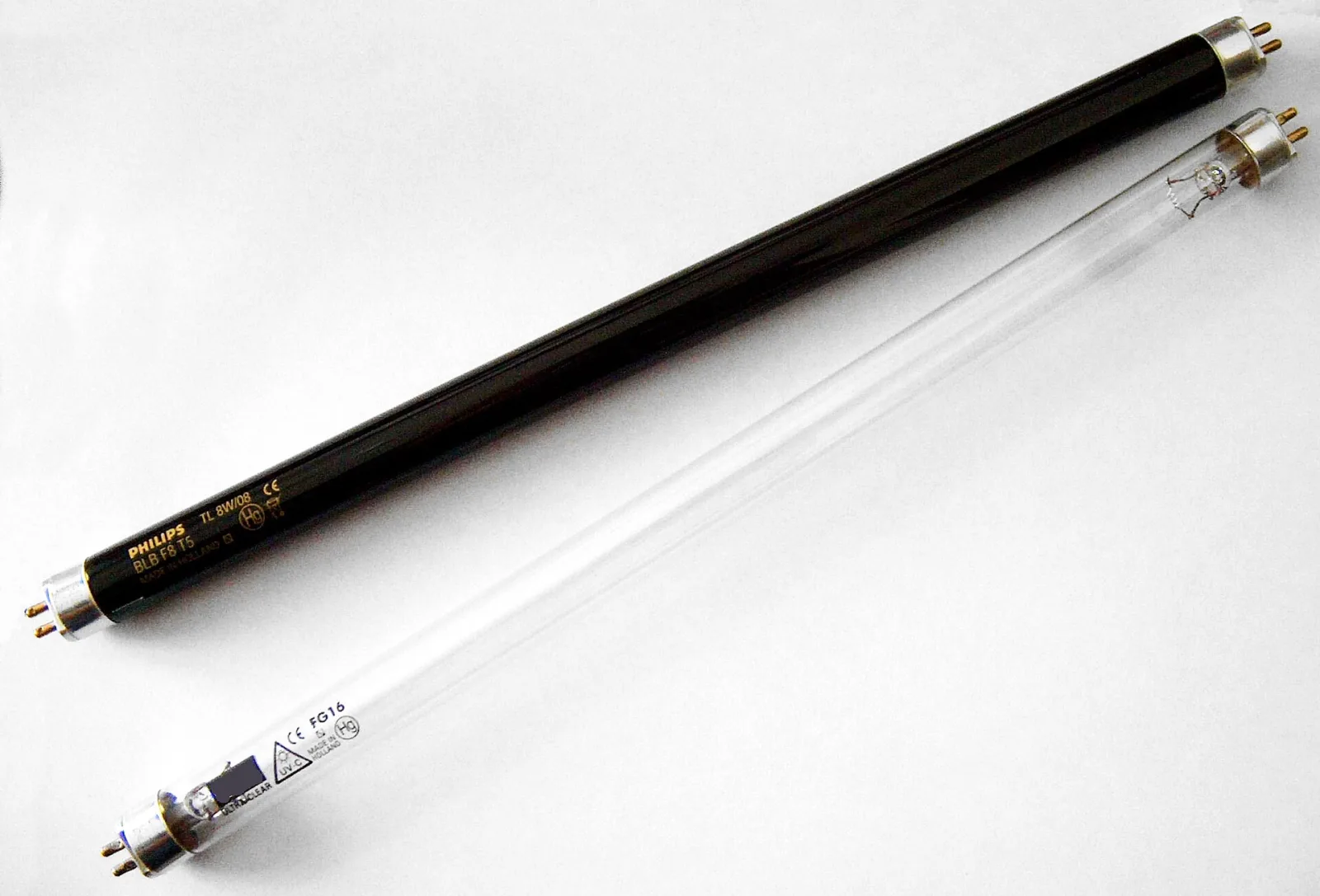 Clear quartz UV-C germicidal lamp tube beside a dark UV-A black-light tube